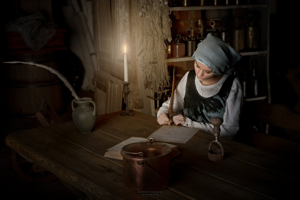 ろうそくの明かりの下で執筆する女性 作： 