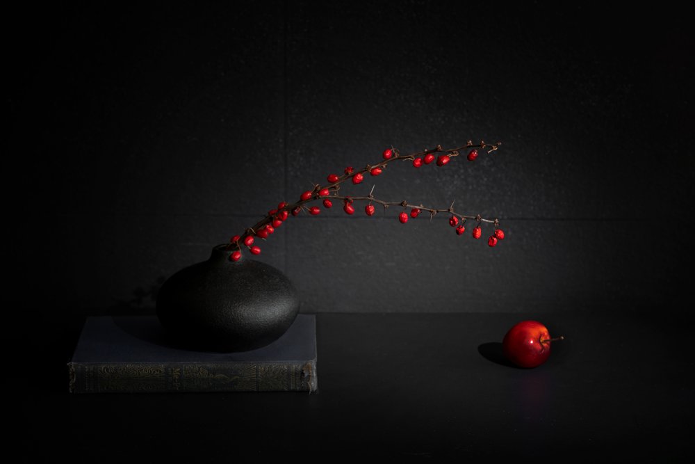 赤いベリーと黒い花瓶の静物画 作： 