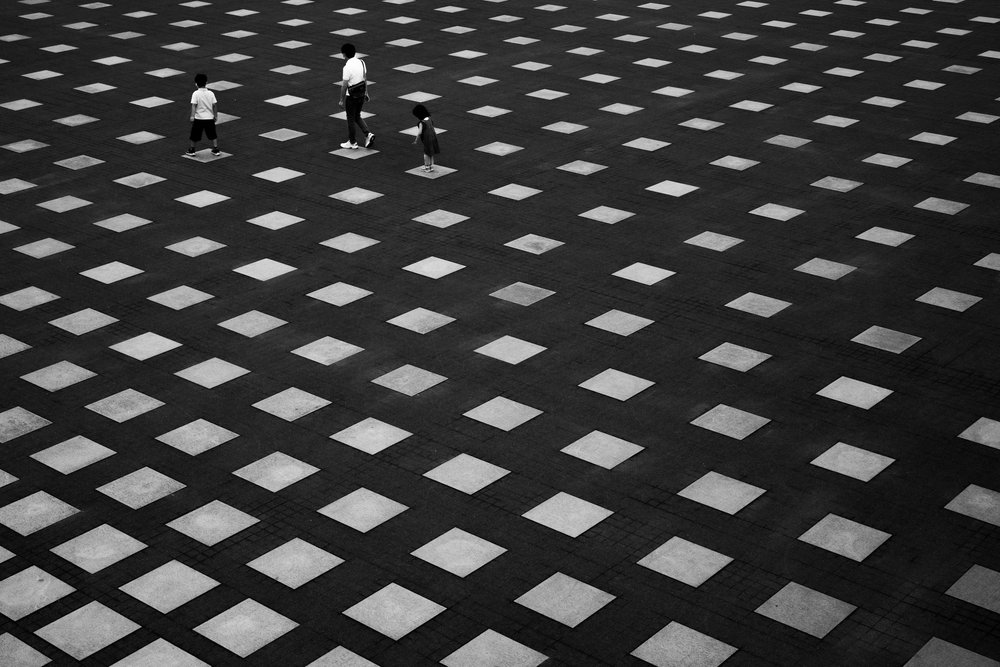 幾何学的な地面の上の人々 作： 