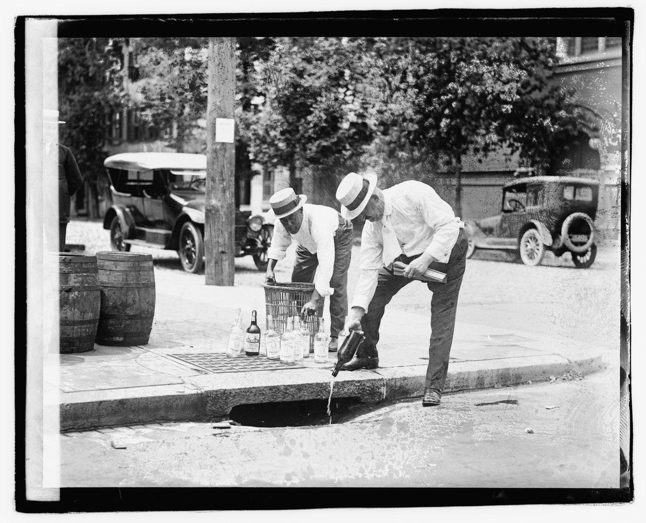 雨水管に酒を注ぐ2人の男（1921年7月8日）（モノクロ写真 作： アメリカの写真家