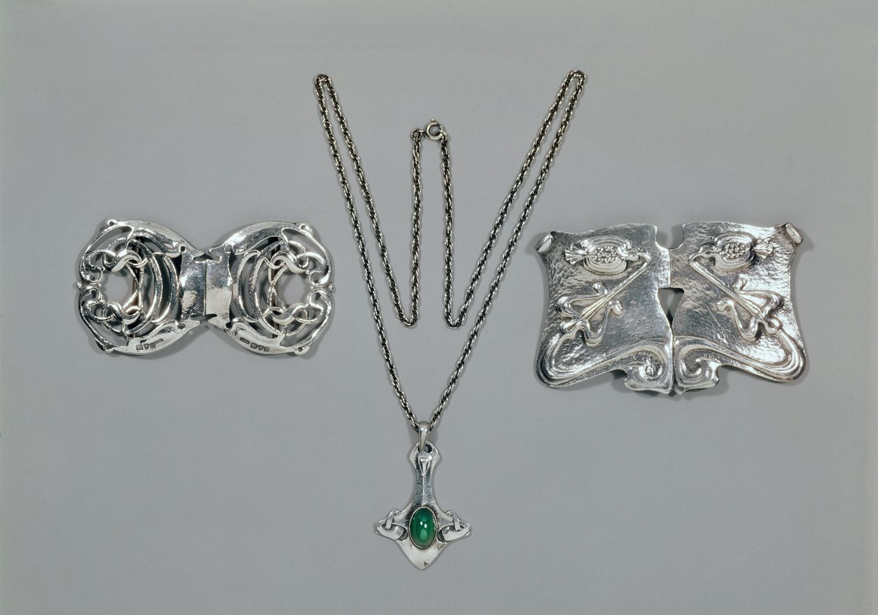 Silberschmuck entworfen für Liberty. Von links nach rechts: Taillenspange mit verschlungenem keltischem Design, 1904. Anhänger und Kette mit Cabochon-Schliff Chrysopras. Taillenspange mit Repousse-Design auf gehämmertem von Archibald Knox