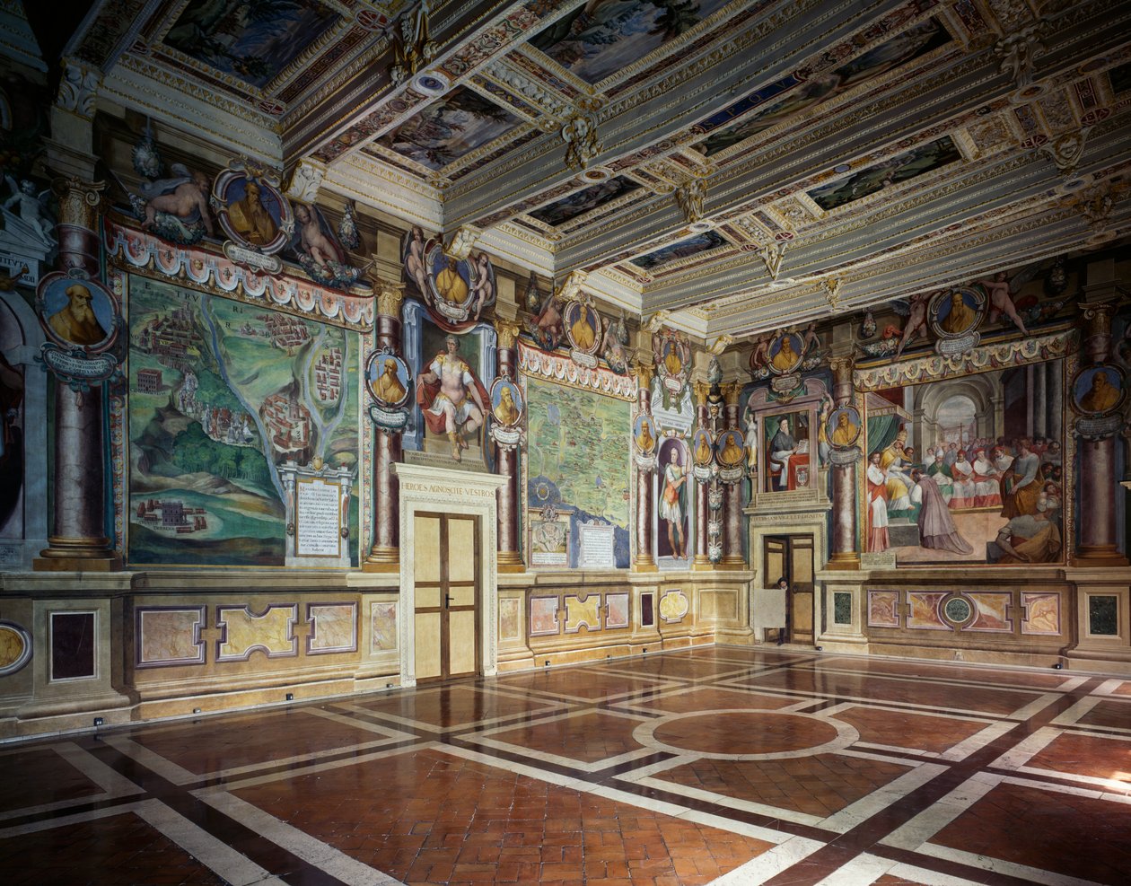 バルダッサーレ クローチェのフレスコ画が描かれたロイヤル ホールまたはヘラクレス ホールで、ヴィテルボ市の神話的および歴史的なシーンが描かれています。市の所有物が飾られた木製の格間天井、市庁舎 (以前のパラッツォ デイ プリオリ)、ヴィテルボ、ラツィオ、イタリア 作： バルダッサーレクローチェ