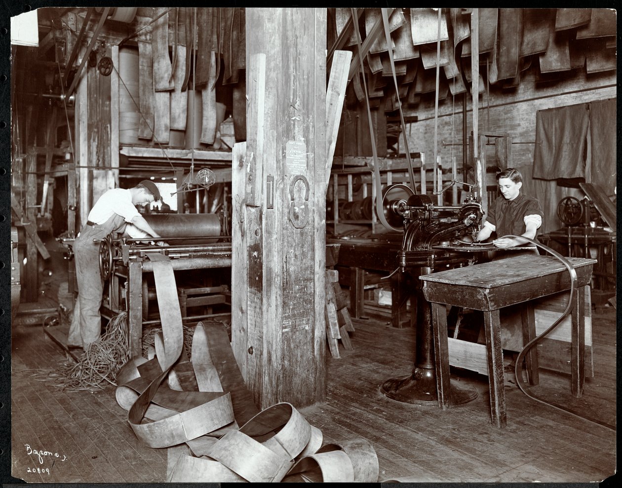 ニューヨークレザーベルト社（1905年または1906年）で革を扱う男性の内部ビュー（銀ゼラチンプリント） 作： バイロンカンパニー