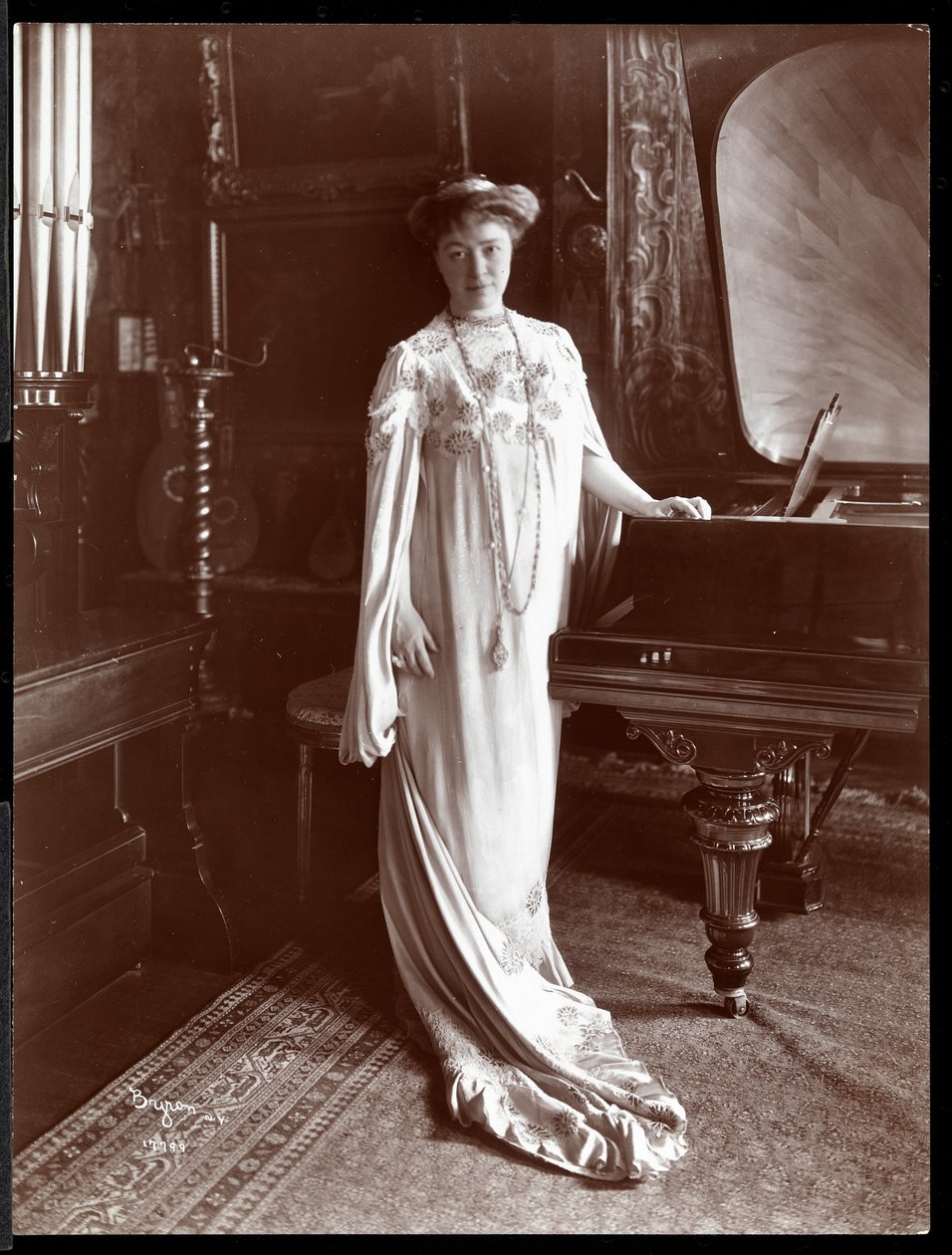 ピアノのそばに立っているIMクラーク夫人の肖像1904（銀ゼラチンプリント） 作： バイロンカンパニー