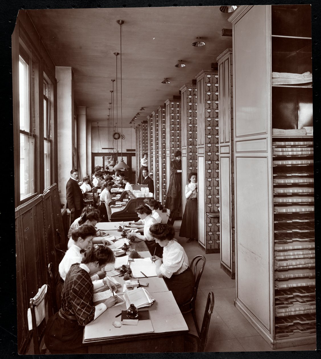 1907年にニューヨークの23rd StreetとMadison AvenueにあるMetropolitan Life Insurance Co.のファイリングルームで働いている女性（男性は銀のゼラチンプリント） 作： バイロンカンパニー