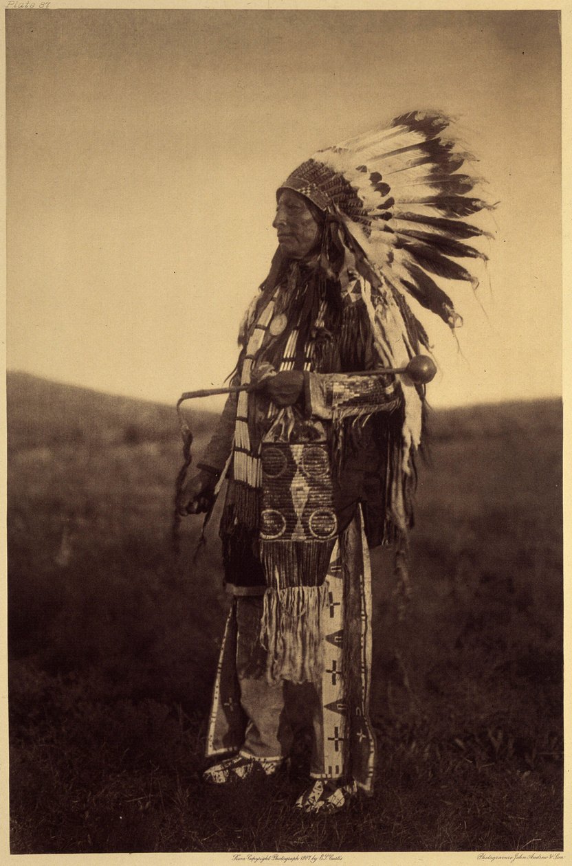 Hight Hawk. Warriorin settimekot hienoon tilaisuuteen: nahkapaita, leggingsit, mokasiinit, piipputuppi (kaikki brodeerattu possueepoksen pikanteilla), sotapäähine kotkan höyhenillä, patukka kivipäällä, päänahalla. Hight Hawk harjoittelee siouxia 作： エドワード保安官カーティス