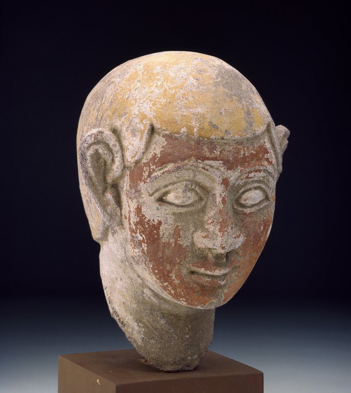 彫像の塗られた砂岩の頭、c.1-300（赤と黄色で塗られた彫刻が施された灰色の台石） 作： エジプト人