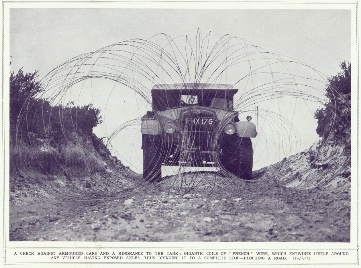 1939年11月22日発行のThe Illustrated War Newsから、装甲車がフレンチワイヤーの巨大なコイルで道路を塞いで止まっている 作： 英語の写真家