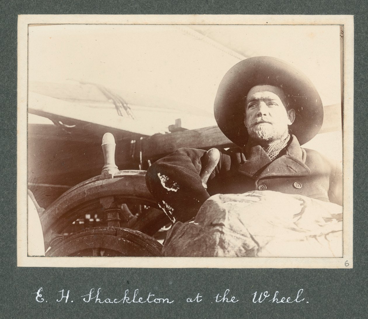 ディスカバリー号」の車輪のそばに立つE・H・シャクルトン（1901年） アーネスト・ヘンリー・シャクルトン卿のアルバム「National Antarctic Expedition（1901-1903）」より。 作： アーネスト・ヘンリー・シャクルトン