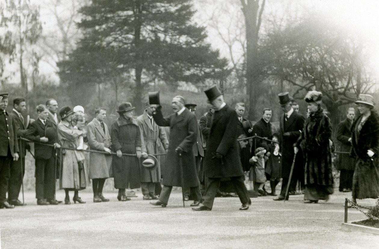 1924年4月に正式に水族館をオープンするためにロンドン動物園を訪問中に、ジョージV世は彼の側近の前で群衆に帽子を上げました。 作： フレデリックウィリアムボンド