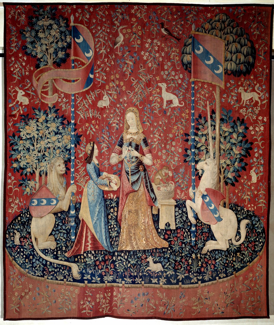 Vorhang der Dame mit dem Einhorn: Allegorie des Geruchs. Eine junge Frau hält einen Kranz aus Nelken, umgeben von einem Löwen, einem Einhorn, einem Affen, Kaninchen. Woll- und Seidenteppich hergestellt zwischen 1484 und 1500. Aus dem Schloss von Boussac, C von French School