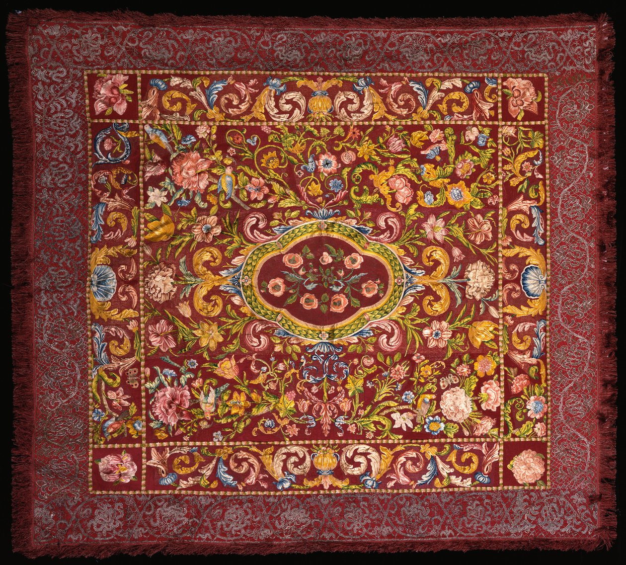 鮮やかな色のシルクで刺繍されたイタリア製のテーブルカーペット。中央にバラのメダリオンが咲き、ユリと大きな花のフィールドの中にあります。 作： イタリア語学校