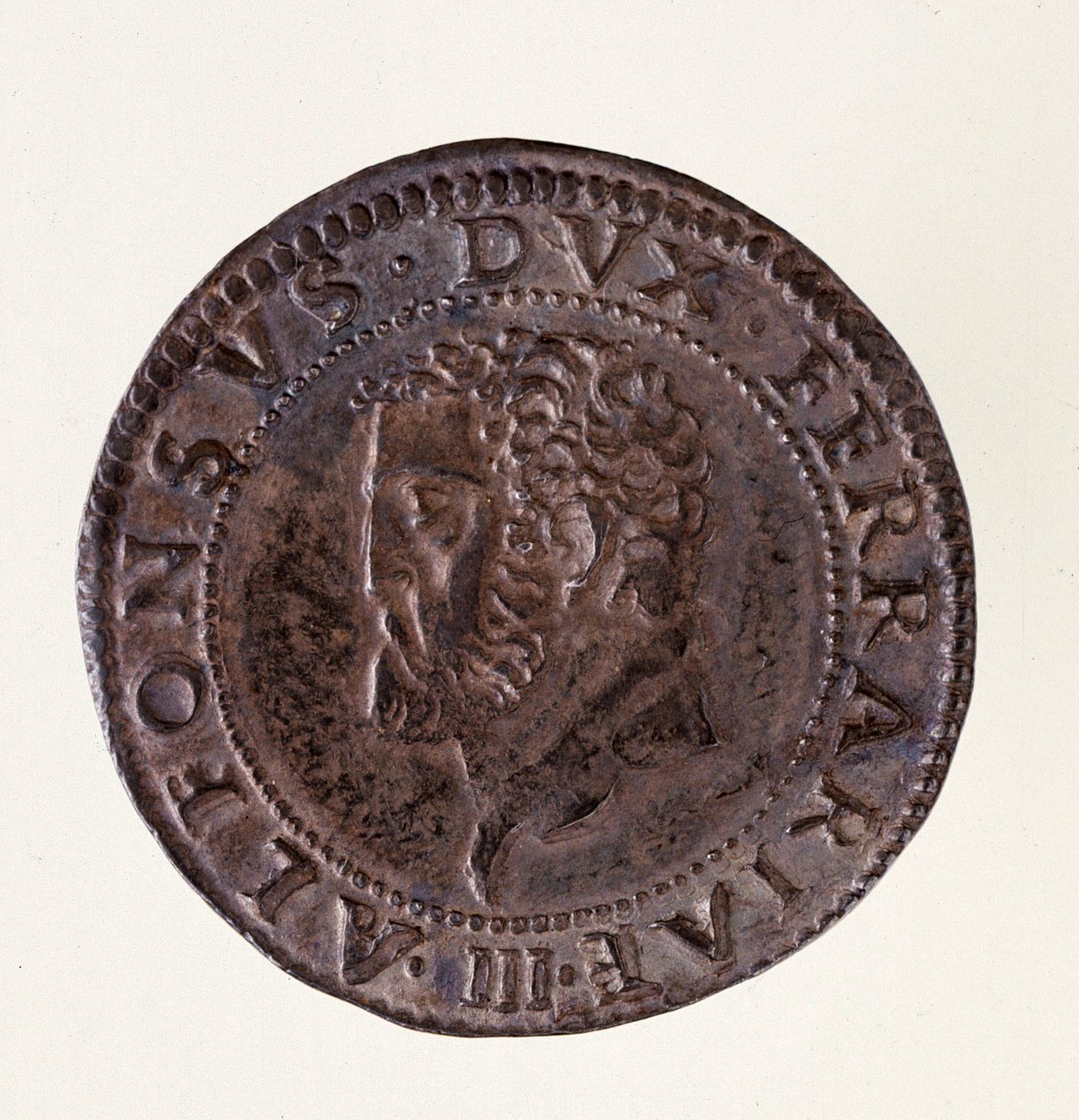 フェラーラ（Ferrara）の銀貨（テストーネ）：公爵アルフォンソ2世デステ（アルフォンス2世エステンセ）の時代（1559-1597年）。直径2.7cm ローマ、イタリア国立博物館 作： イタリア語学校