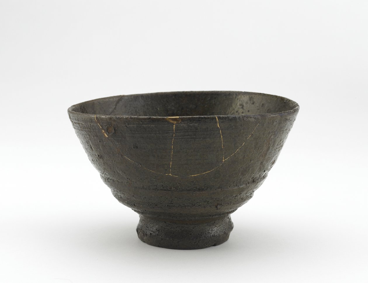 18世紀初頭、くぎぼりいらぼ風の楽山焼茶碗（灰釉の石器、金漆の補修） 作： 日本語学校