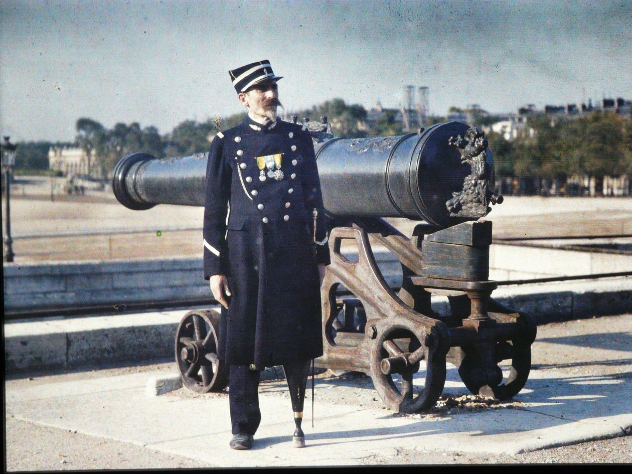 1918年、パリの大砲の隣に3つのメダルを備えた制服を着た兵士が立っています（オートクローム） 作： ジュール・ジェルヴェ・コートテルモント
