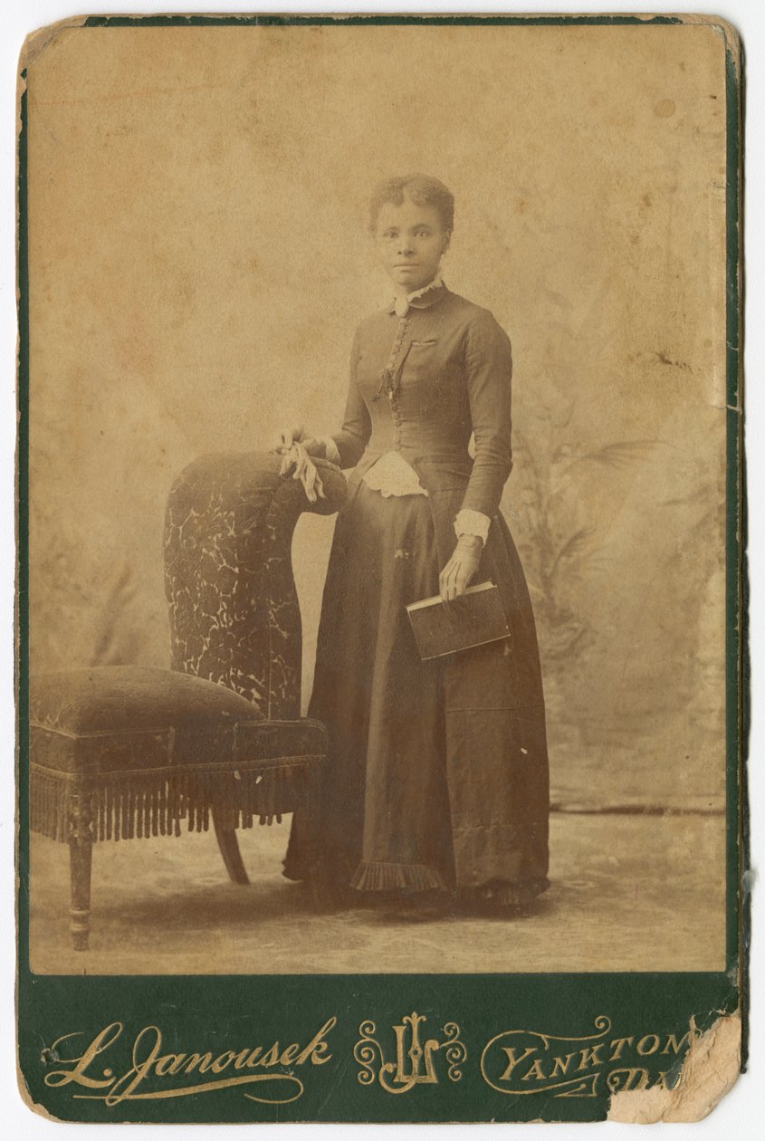 椅子の横に立って本を持っている女性の写真 19世紀後半 作： Louis Janousek