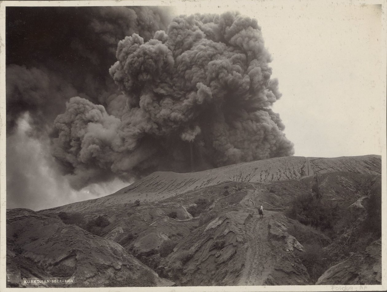 オランダ領東インドの煙る火山の近くで馬を持つ男 作： Onnes Kurkdjian