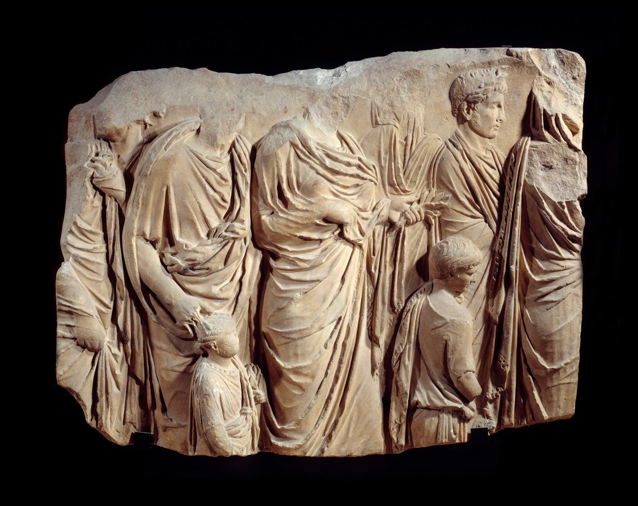 ローマ美術：アラ・パシス・アウグスタエ（平和の祭壇）の行列の大理石製建築用レリーフの断片：トーガを着た人物と子供たちの行列で、生け贄の儀式中。紀元前13-9年頃。ローマ（シャン・ド・マルス、パレ・フィアーノ）で発見。1.1×1.4メートル 作： 小説