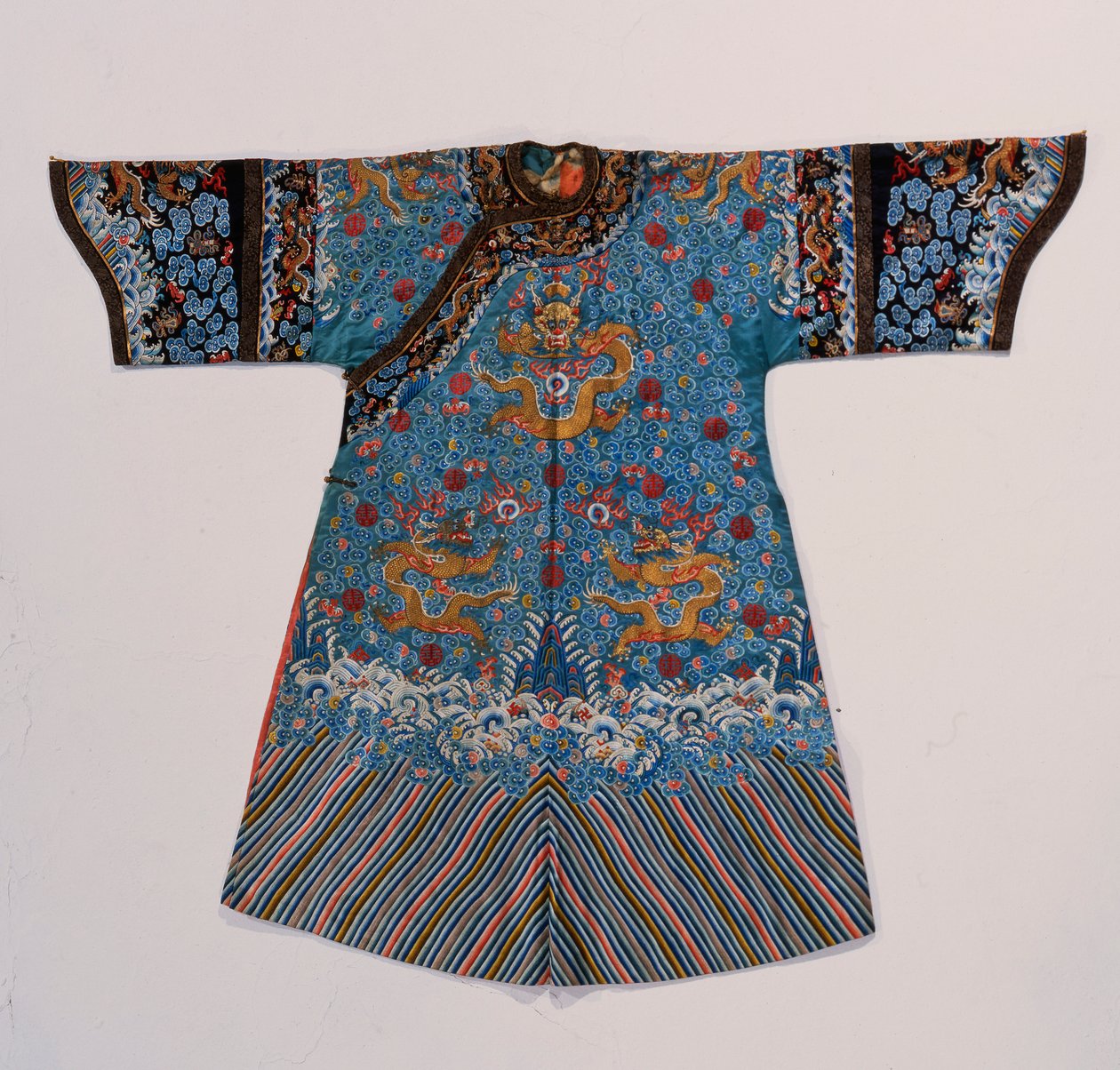 ターコイズサテンのインペリアルコンソートのフォーマルなコートローブ（Chi&39;fu）は、シルクで刺繍され、海の波の境界（サテン、シルク）の上に、スクロールする雲、赤い翔のキャラクターシンボル、コウモリに囲まれた9つの金色のドラゴンが付いた金色の糸で飾られています。 作： 学校の中国語