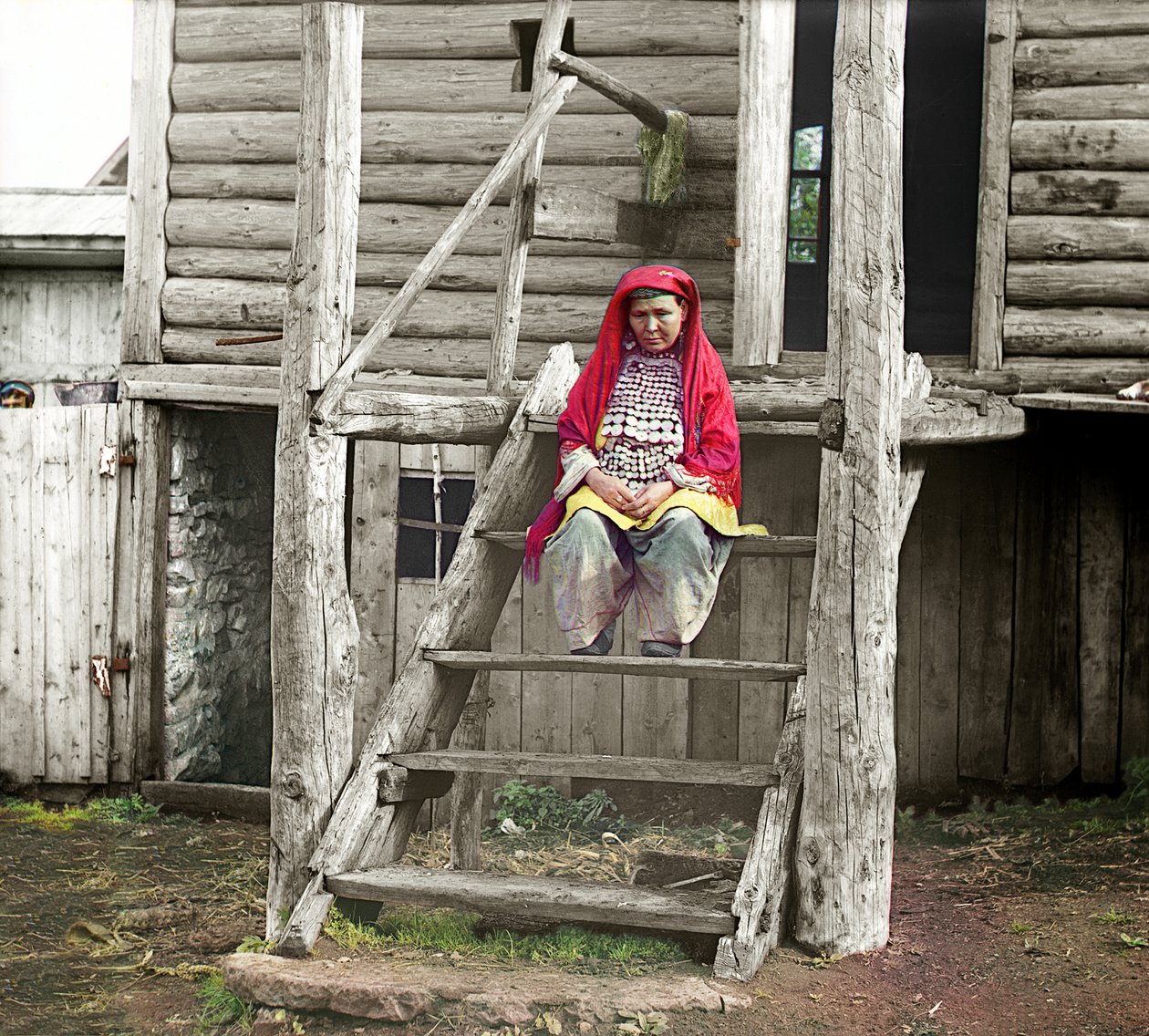 木造住宅、ウラル山脈、ロシア帝国、1910年の階段に座っている民族衣装のバシキール州の女性 作： セルゲイ・プロクディン・ゴルスキー