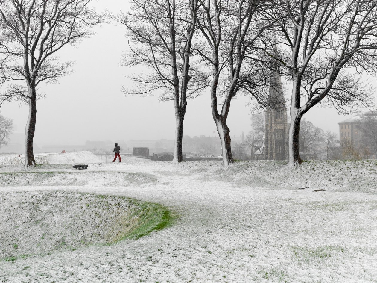 吹雪の中、コペンハーゲンの要塞を歩く一人の人物（デンマーク、2022年）（写真）。 作： シセ・ブリンベルグ