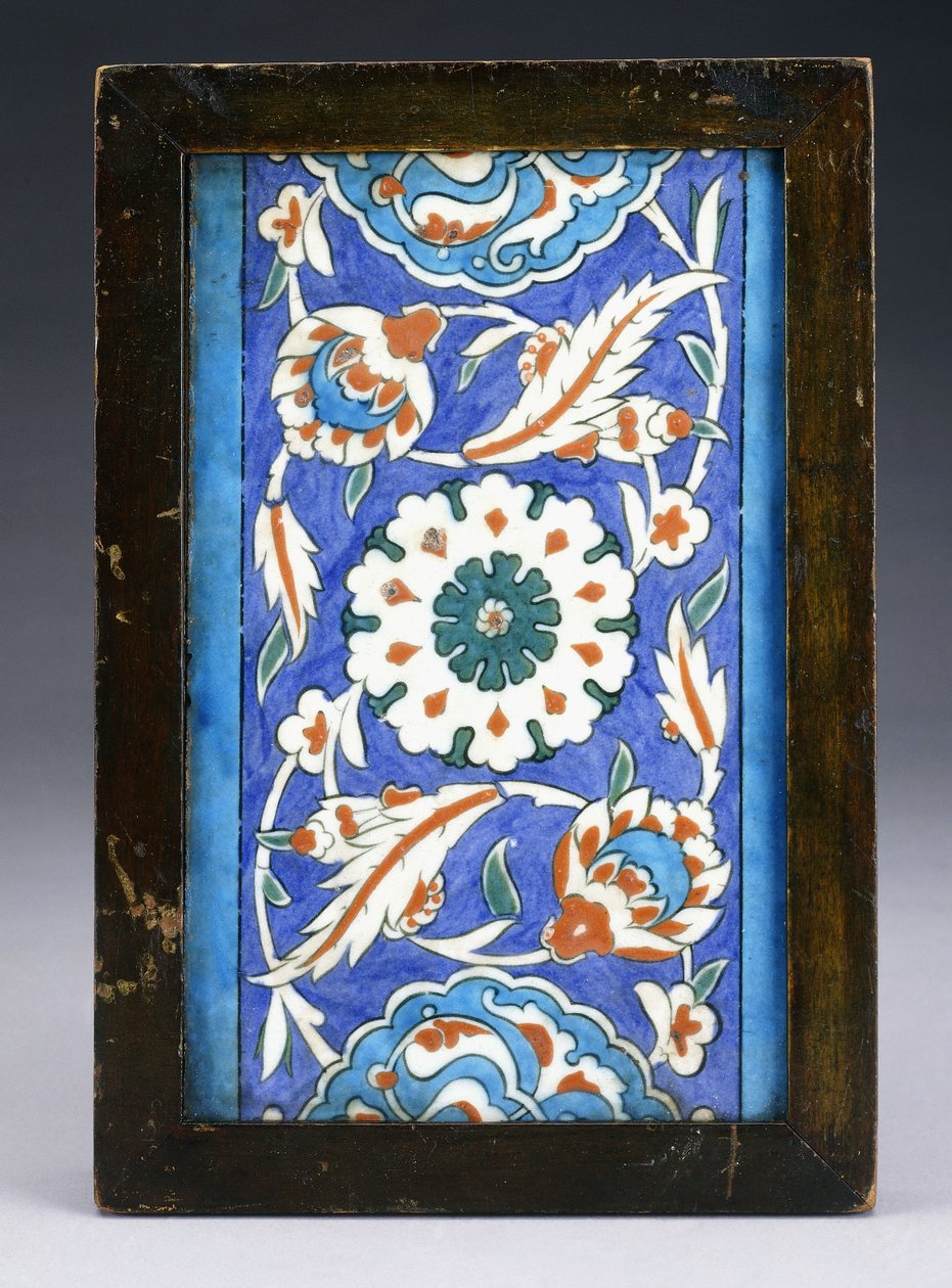 スクロールするパルメットと緑豊かなつるの間に中央の花頭があるイズニックボーダータイル、c.1570（セラミック） 作： トルコ語学校