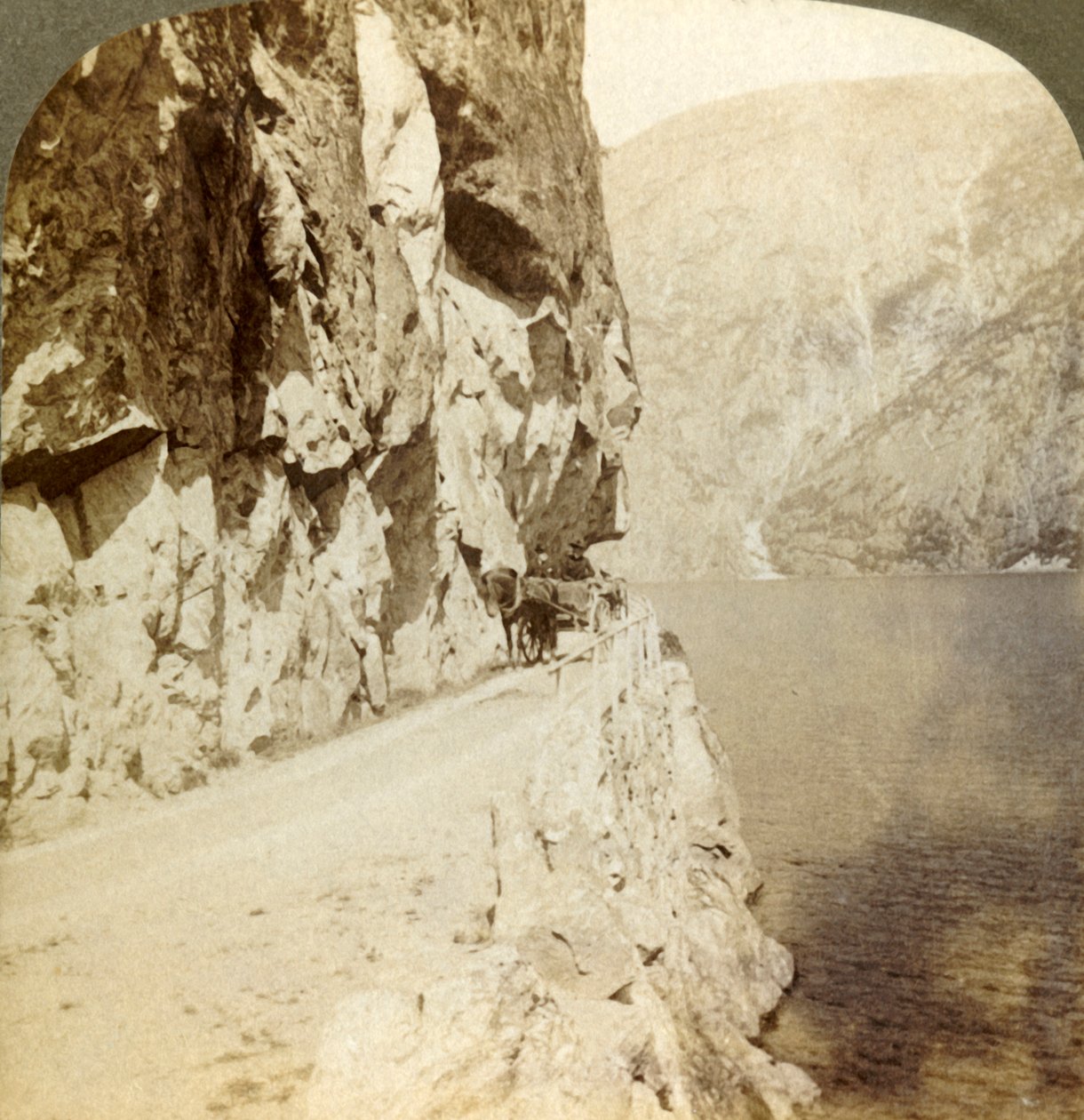 1905年、ノルウェーのオイフィヨルズ湖周辺の道にそびえ立つ崖から道が吹き荒れました。 作： 不明