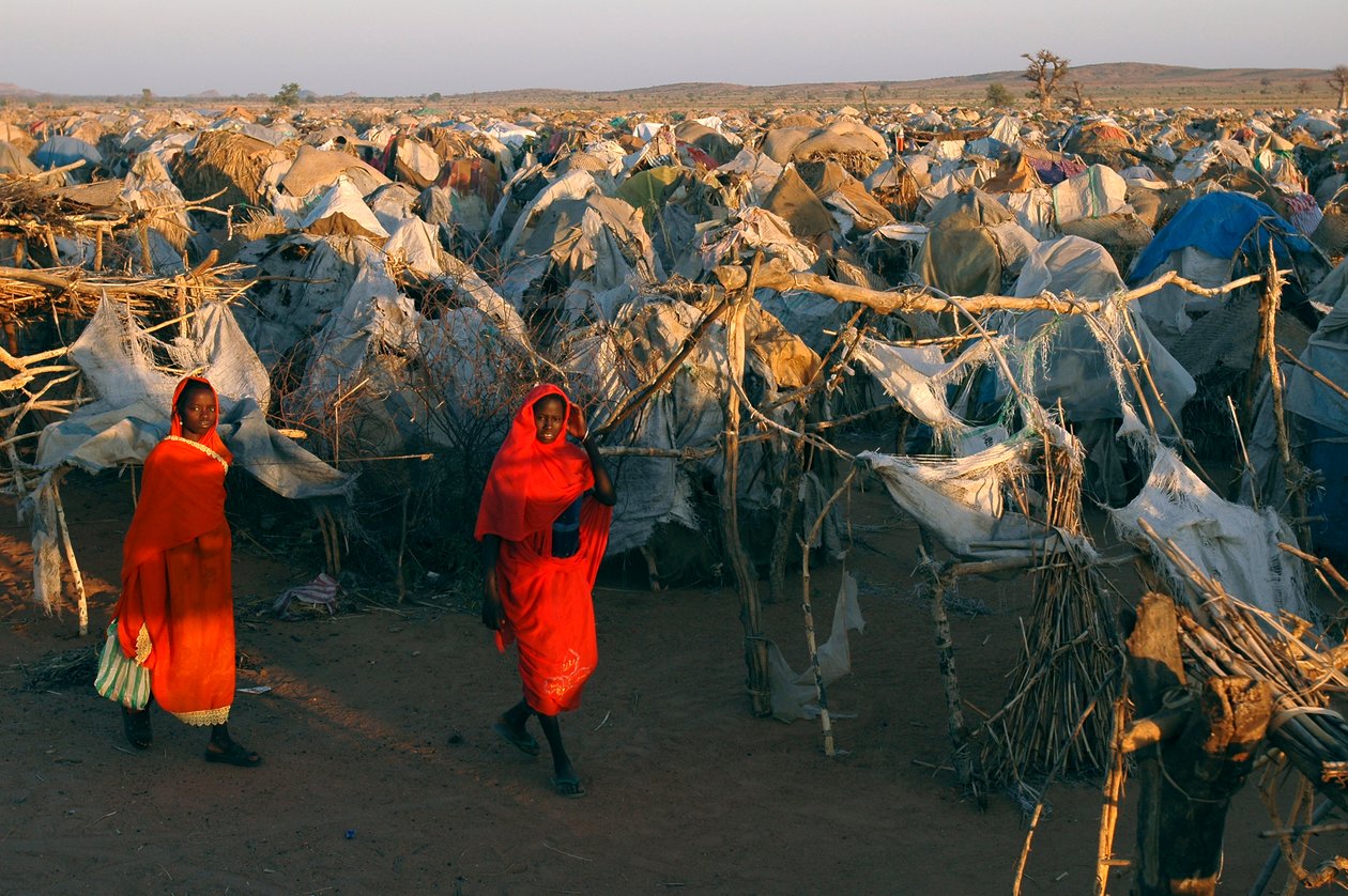 真っ赤な服を着た女性は、国内避難民のためのオタッシュキャンプを歩く 作： 不明不明