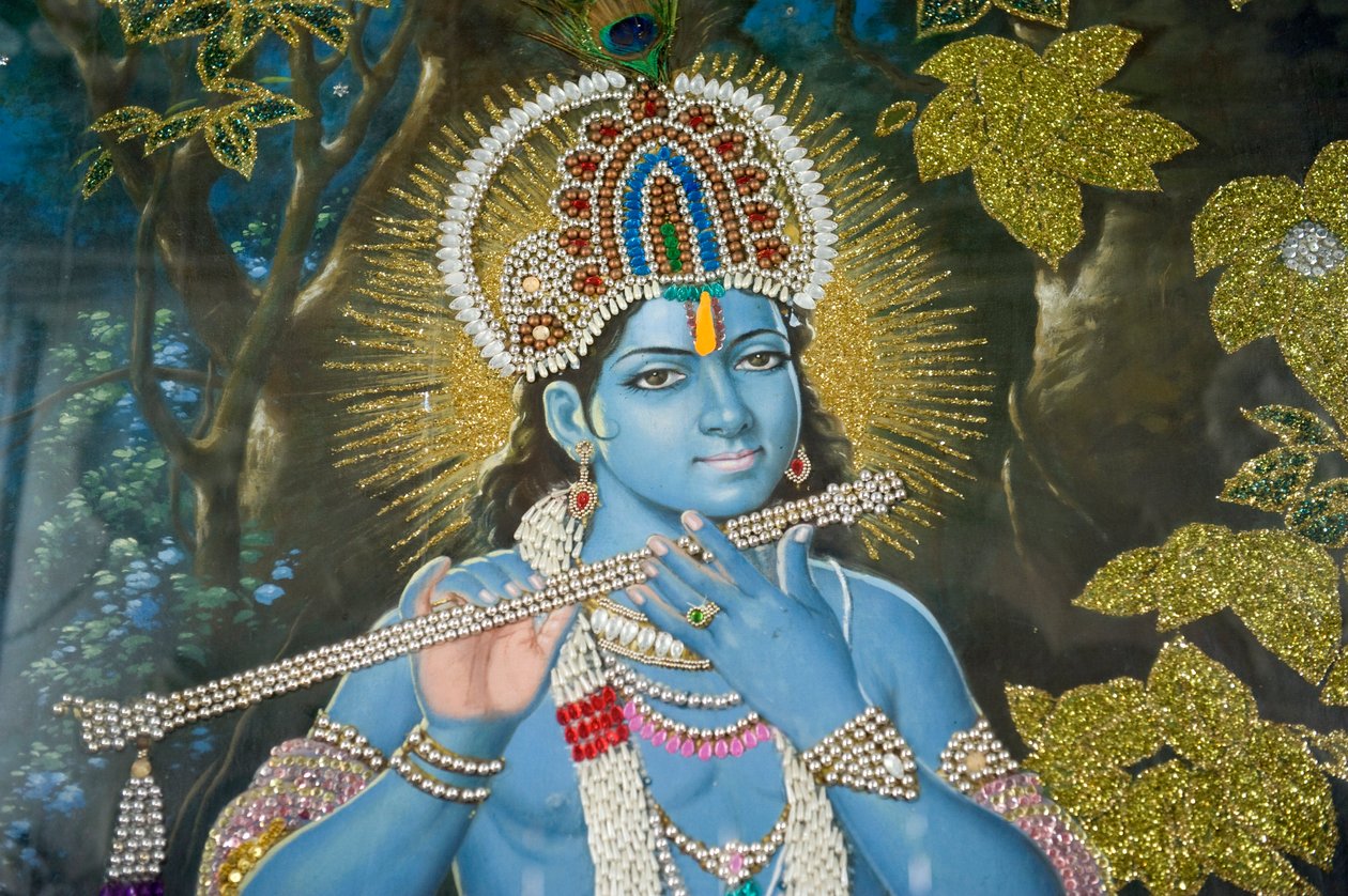 屋外で笛を吹くヒンドゥー教の神クリシュナを描いた絵画。インド