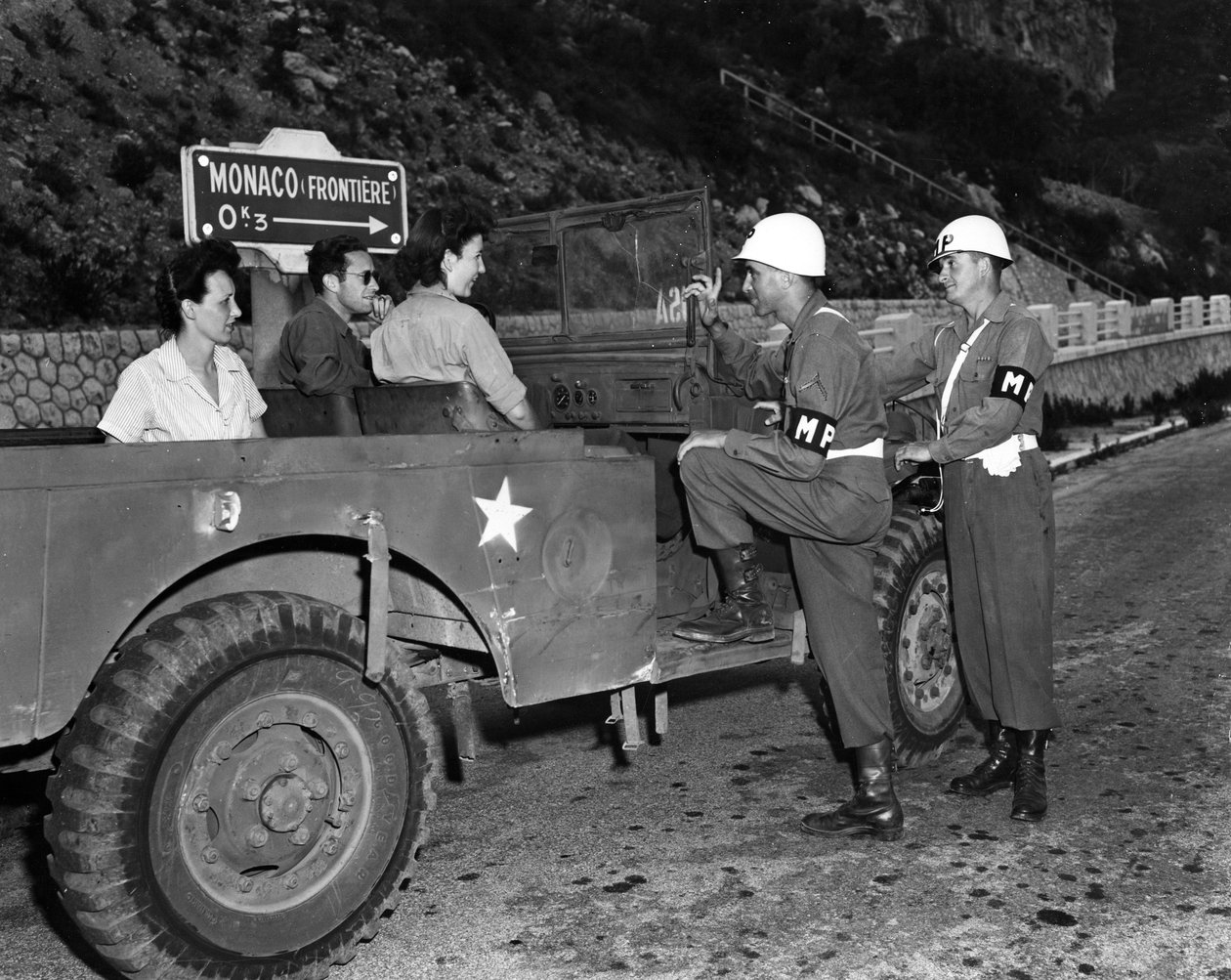 第二次世界大戦(1939-1945) - World War II (WWII or WW2):モナコフレンチリビエラ付近 1945年6月30日。米国リビエラ保養地（USRRA）のゲストである休暇中の2人のワックが、モネの端に駐留する2人の米軍憲兵と話し合う 作： 不明