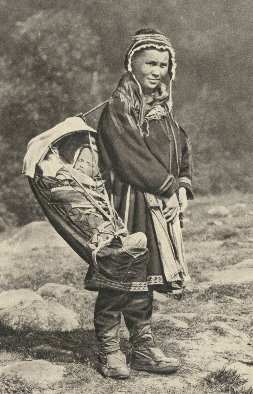 スウェーデン。トナカイの皮でできた揺りかごに赤ちゃんを抱くラップ族の女性。1920 作： 不明