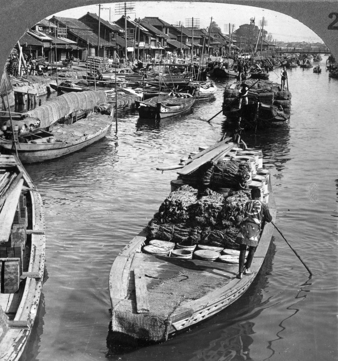 1904年に東京で忙しい貨物運河。 作： アンダーウッドとアンダーウッド
