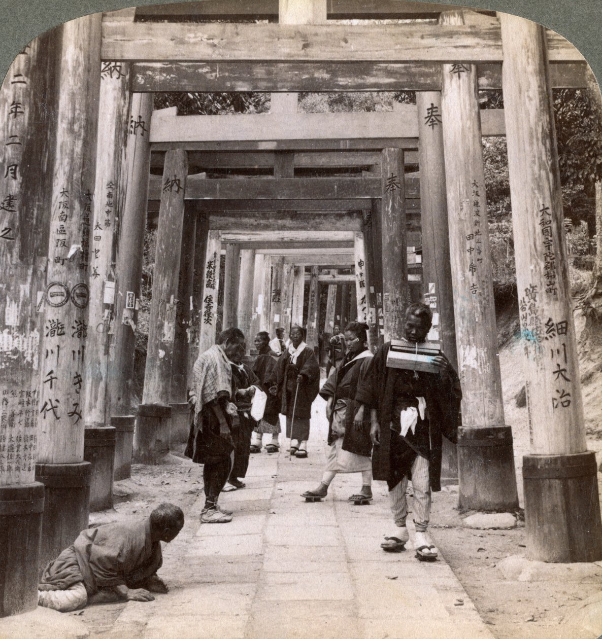 聖なる鳥居の長い列の下を行き来する、稲荷神社、京都、1904 作： アンダーウッドとアンダーウッド