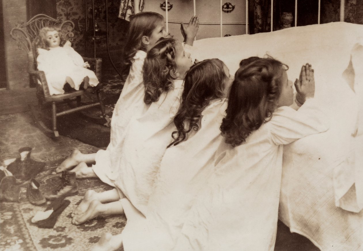 ベッドの脇にひざまずき、夕べの祈りをささげる4人の少女たち。 作： 未知の写真家
