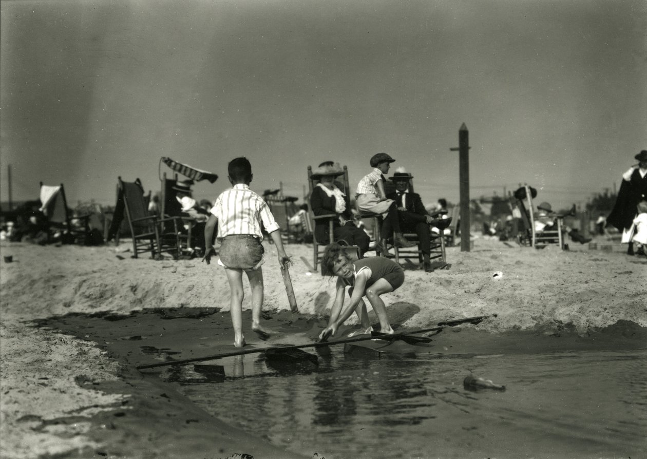 2人の子供がコニーアイランドの浅瀬で木くずと遊んでいる、c.1910-21 作： ウィリアムデイビスハスラー