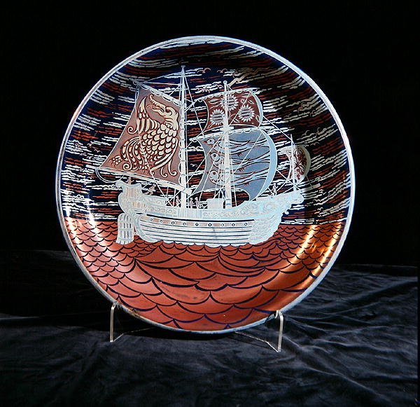 赤色の海に帆を張るガレオン船を描いた銀色光沢のチャージャー（陶製） 作： ウィリアム・ド・モーガン