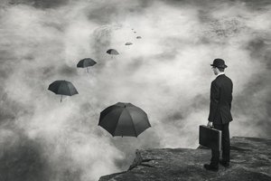 男と空に浮かぶ傘たち