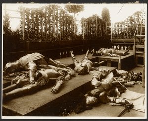 [死んだふりをする鎧に身を包んだ古代の戦士に扮した6人の男性モデル]。 作： Alphonse Maria Mucha