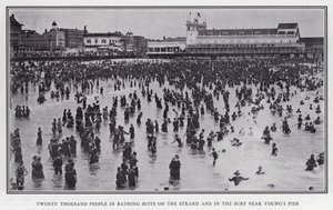 水着を着た2万人の人々がヤング・ピア近くの海岸や波打ち際に集まってくる（モノクロ写真 作： American Photographer (after)
