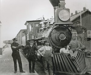 ネバダ州ミルシティに停車中のセントラル・パシフィック鉄道の貨物列車と乗務員 作： American Photographer