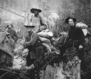 クロンダイクゴールドラッシュ（1897-98年）でカナダのユーコン準州に移動した金鉱探しの人々（モノクロ写真）。 作： American Photographer