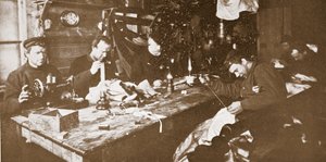 真冬の小屋では、男性は春のそり遊びやパブで使用する衣服の毛皮を縫う作業に従事していました。 ロンドン 1907 (白黒写真)