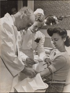 [医師と看護師が女性の腕に針を刺す] 作： Arnold Eagle