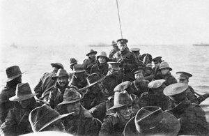 1915年4月25日、着陸の日の午前6時にアンザックコーブに向けて曳航されている、オーストラリア第1師団信号会社の身元不明の男性を運ぶ救命ボートの後方を見る図（bw phot 作： Australian Photographer