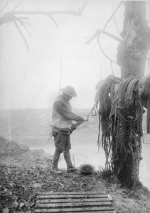 1916年12月、マメッツ近郊のビレットのチームハーネスから泥を掃除しているオーストラリアの正体不明の大砲ドライバー 作： Australian Photographer