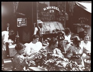 1898年にニューヨークのヘスターストリートで行商人から野菜を買おうとする女性たちの様子（銀ゼラチンプリント）