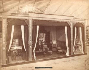 James Shoolbred & Co.の展示 -- 本館、家具のある3つの部屋。左側の部屋には、3つのキャビネットと洗面器、湯沸かし器、鏡があり、中央の部屋には、テーブル、椅子、長椅子、鏡と彫刻のあるサイドボードがあり、T 作： Centennial Photographic Co.