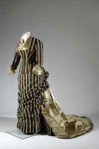 イブニング・ドレス、1884年頃（側面斜視図）。シルクサテン、カットベルベット、レース、シルク糸のタッセルとフリンジ。チャールズ・フレデリック・ワース、フランス。 作： Charles Frederick Worth