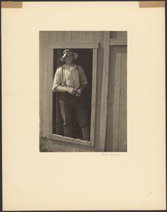[納屋の戸口に立つ麦わら帽子の男、煙草入れを持つ]。 作： Doris Ulmann