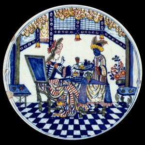 デルフト磁器の皿に描かれた、黒人の召使が給仕する食卓の女性の姿。1705年 セーブル、国立陶磁器博物館 作： Dutch School